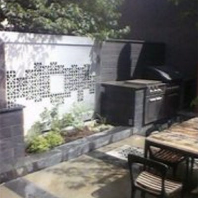 Patio Barbeque Area with Seating and Detailed Stonework Artwork by European Garden Design Calgary