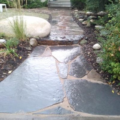 Natural Stone Walkway in Front of House Stonework by European Garden Design Calgary